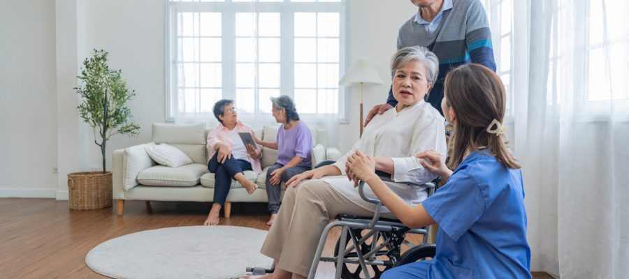 Asian young nurse support couple senior older man and woman in a wheelchair. elderly mature and a group of senior friends living in the hospital. socializing of retired people.